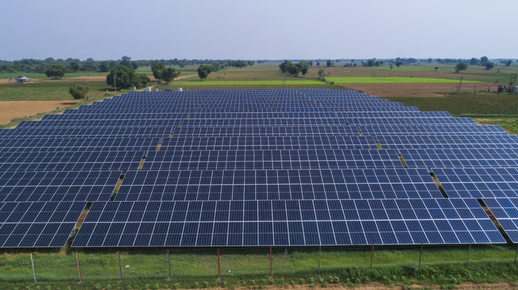 Aerial view of a ground-mounted solar plant across agricultural land